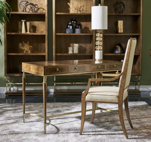 Luxury home office furniture by Jonathan Charles featuring a writing desk, upholstered chair, three bookcases and a decorative table lamp in an elegant study setting.