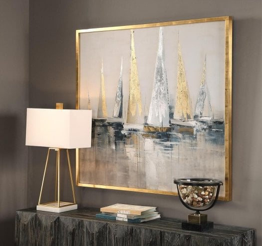 Luxury home accessories featuring framed wall art, decorative accessories, table lamp and sculptural decor styled on a rustic sideboard.