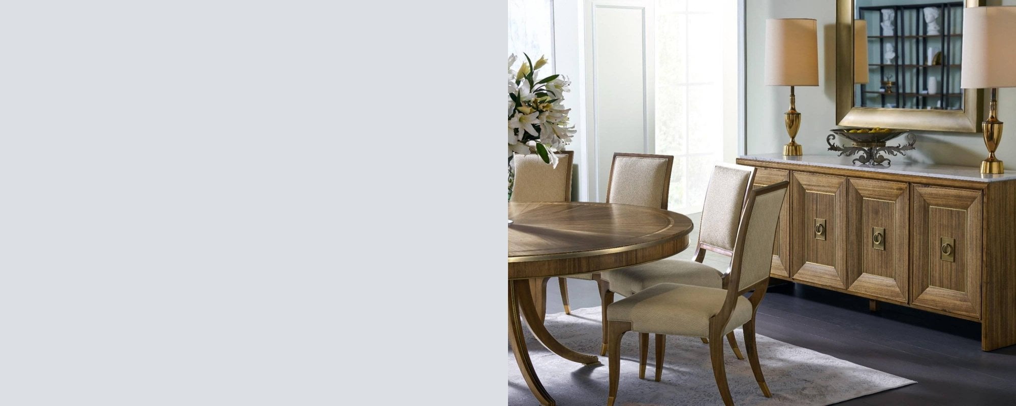 Jonathan Charles Hamilton Collection dining room furniture featuring a round dining table, upholstered dining chairs, sideboard and statement wall mirror in an elegant interior.