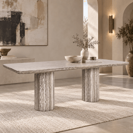 Nebula modern travertine dining table with twin cylindrical pedestal bases, styled in a contemporary neutral interior with sculptural decor and natural textures.