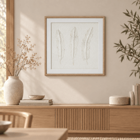 Solli white feathers framed wall art displayed above a natural wood sideboard in a neutral Japandi interior with ceramic decor and dried foliage.